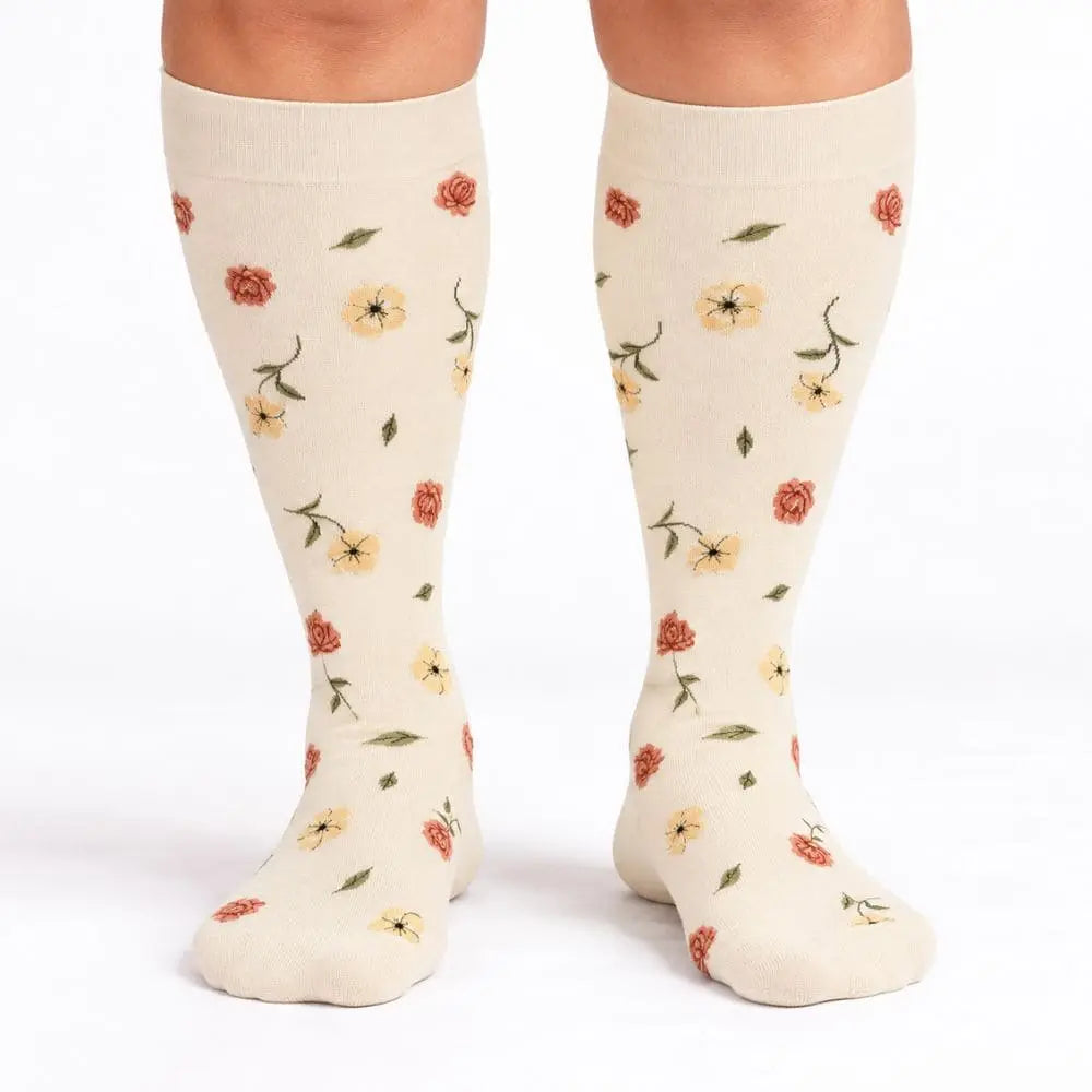 Produktfoto: Mevery Kompressionsstrumpf Rosengarten in Creme mit kleinen Rosen und gelben Blüten
Getragen: Frau trägt Mevery Kompressionsstrümpfe Rosengarten in Creme mit Rosenmuster, Ansicht von vorne